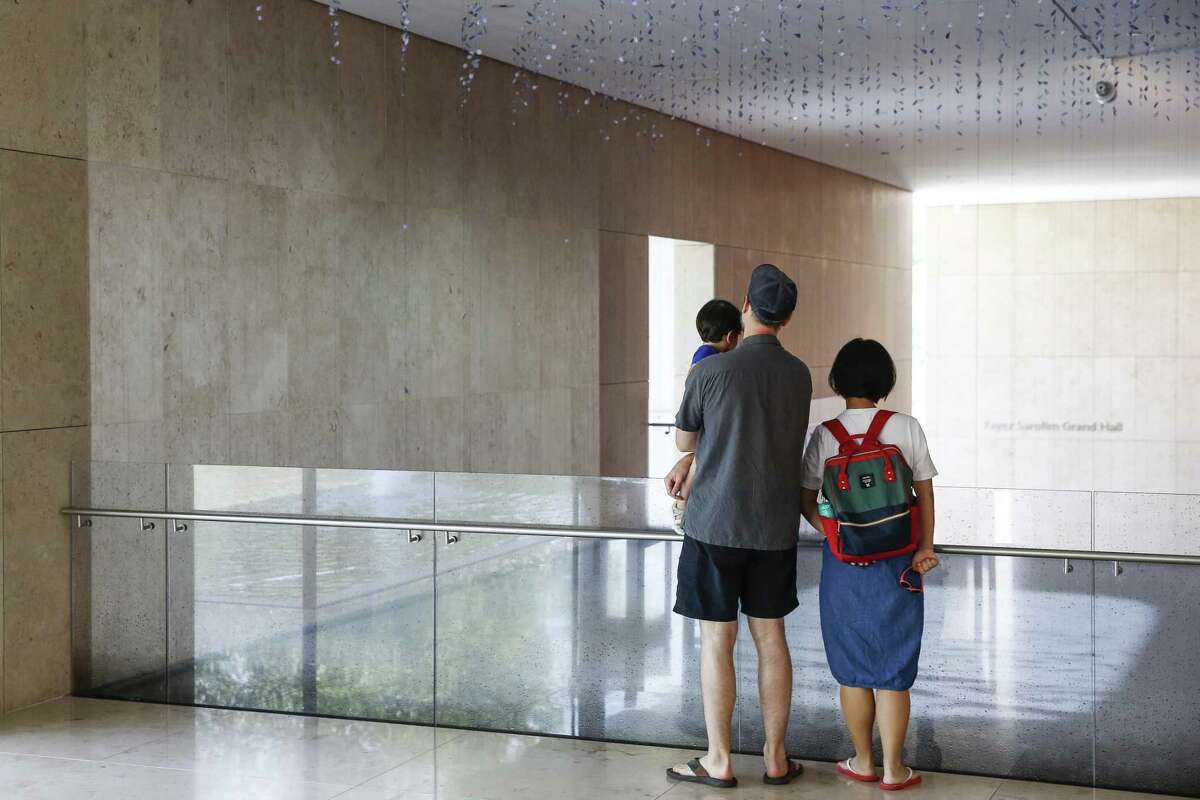 Parker Trevathan holds his daughter, Vera Trevathan, while looking at Japanese artist Ayomi Yoshida’s installation “Ayomi Yoshida” with his wife, Yunnan Zhang at the Asia Society Texas Center.