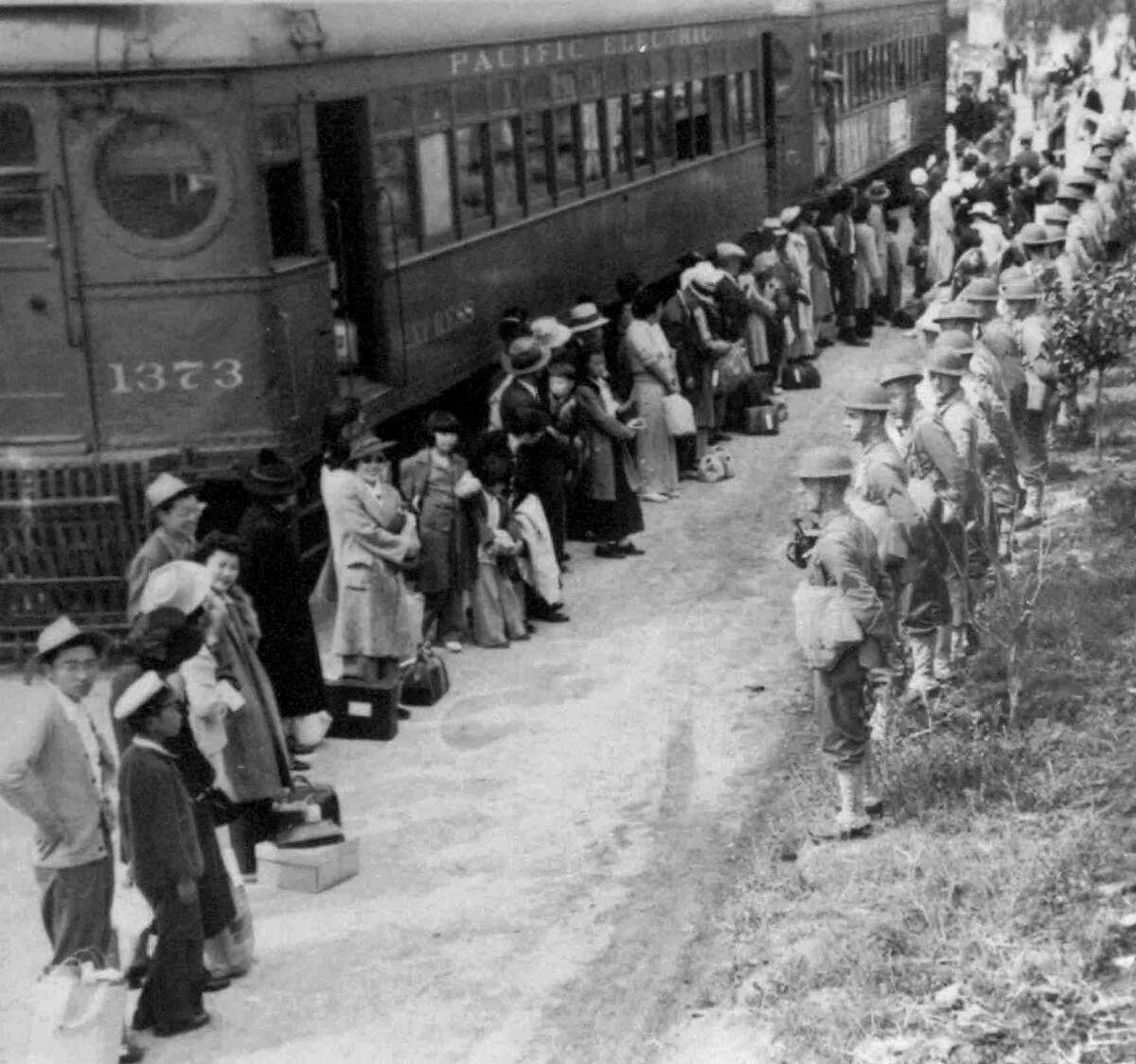 ADVANCE FOR SUNDAY, SEPT. 30--People of Japanese descent line up for a train that will take them from the Santa Anita assembly camp in California to an internment camp at Gila River, Ariz. in 1942. U.S. soldiers face them, right. The internment of Japanese during World War II required the suspension of civil rights for the minority group. (AP Photo/National Archives)