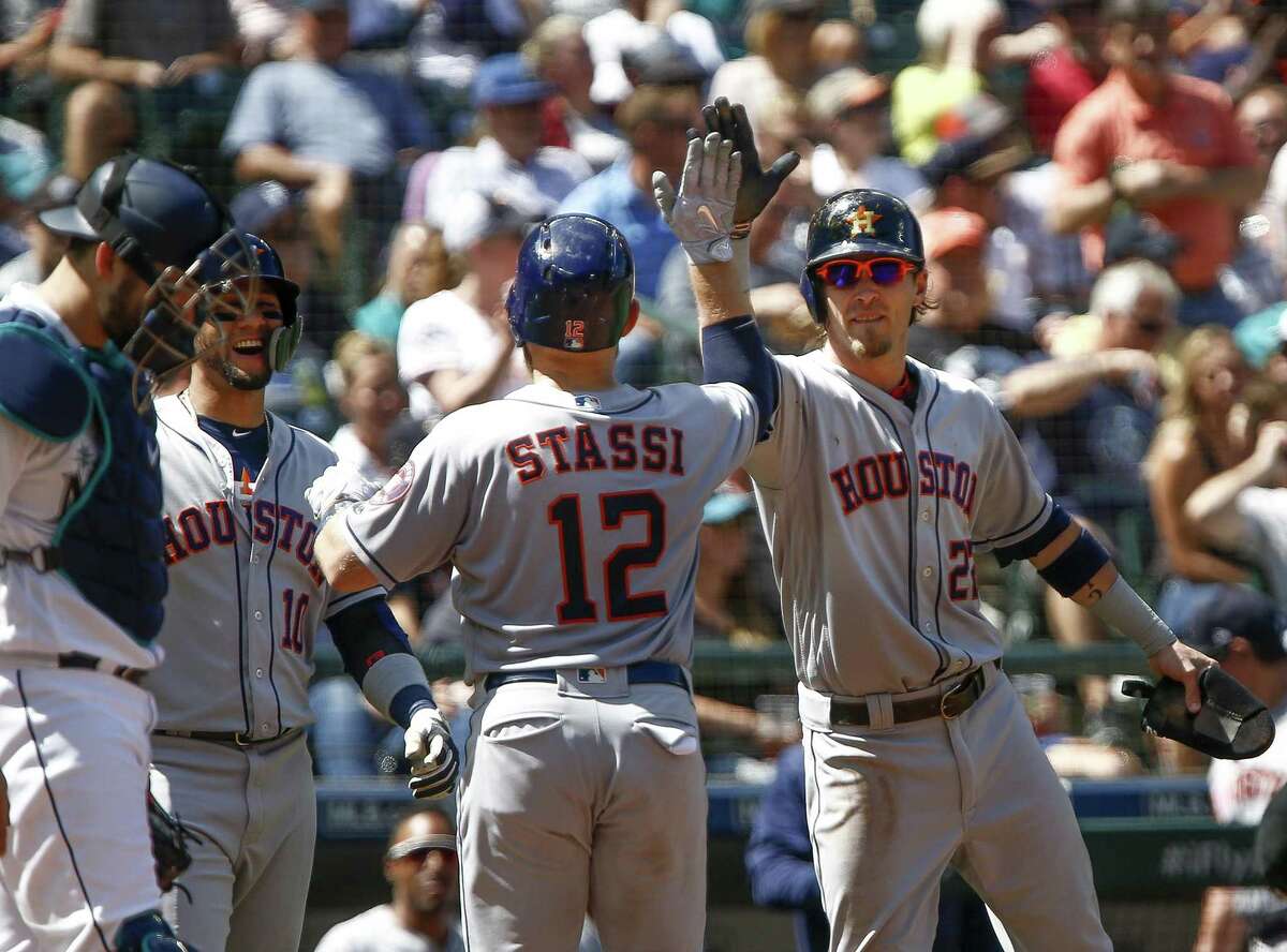 Max Stassi is greeted by Yuli Gurriel (10) and Josh Reddic k (22) after completing the Astros’ scoring with a three-run homer in Wednesday’s fifth inning.