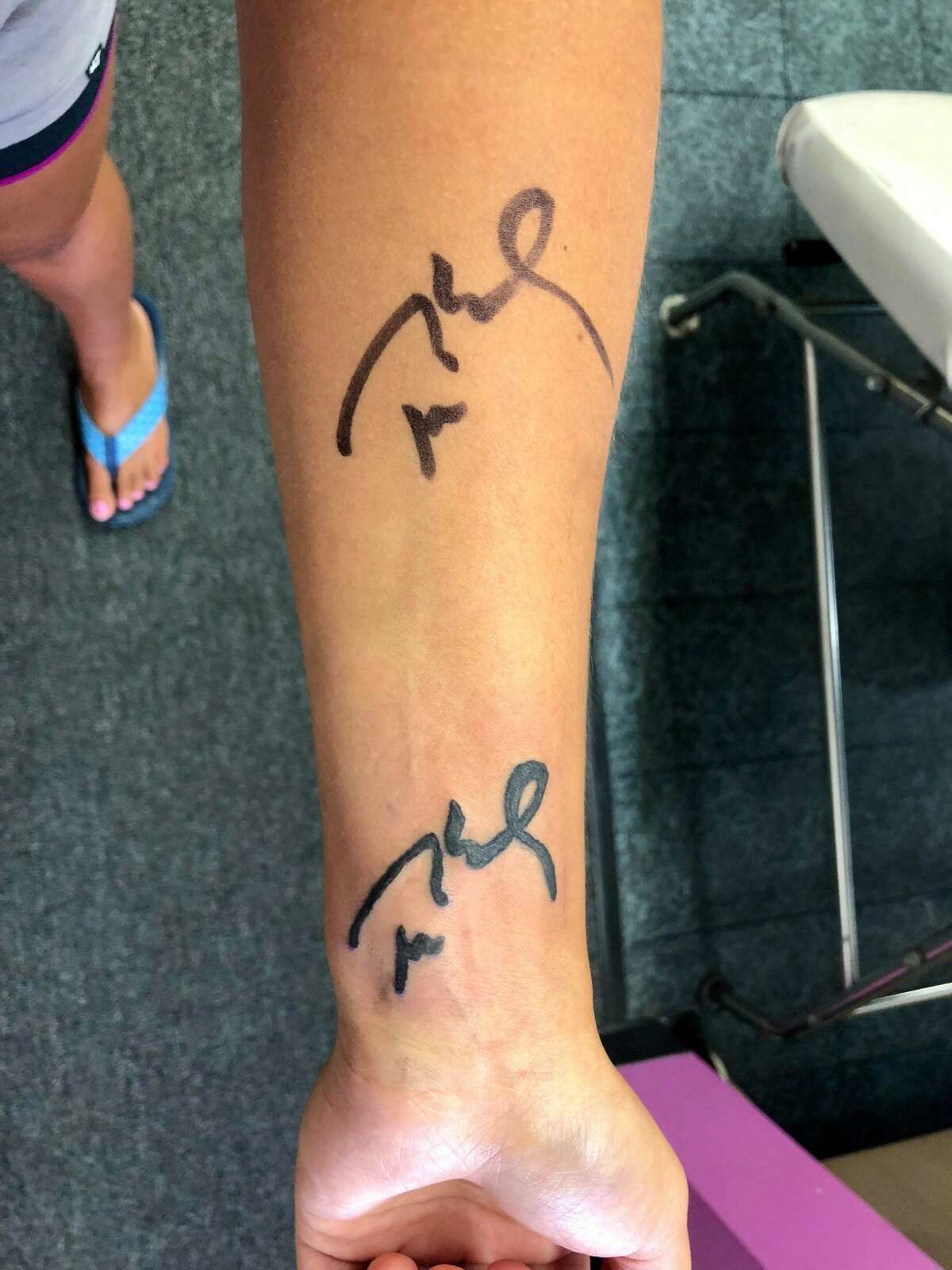 Startford resident Megan Uhrynowski, 19, got a tattoo of Tom Brady's signature on her arm. The original autograph is on her forearm; the tattoo is on her wrist.