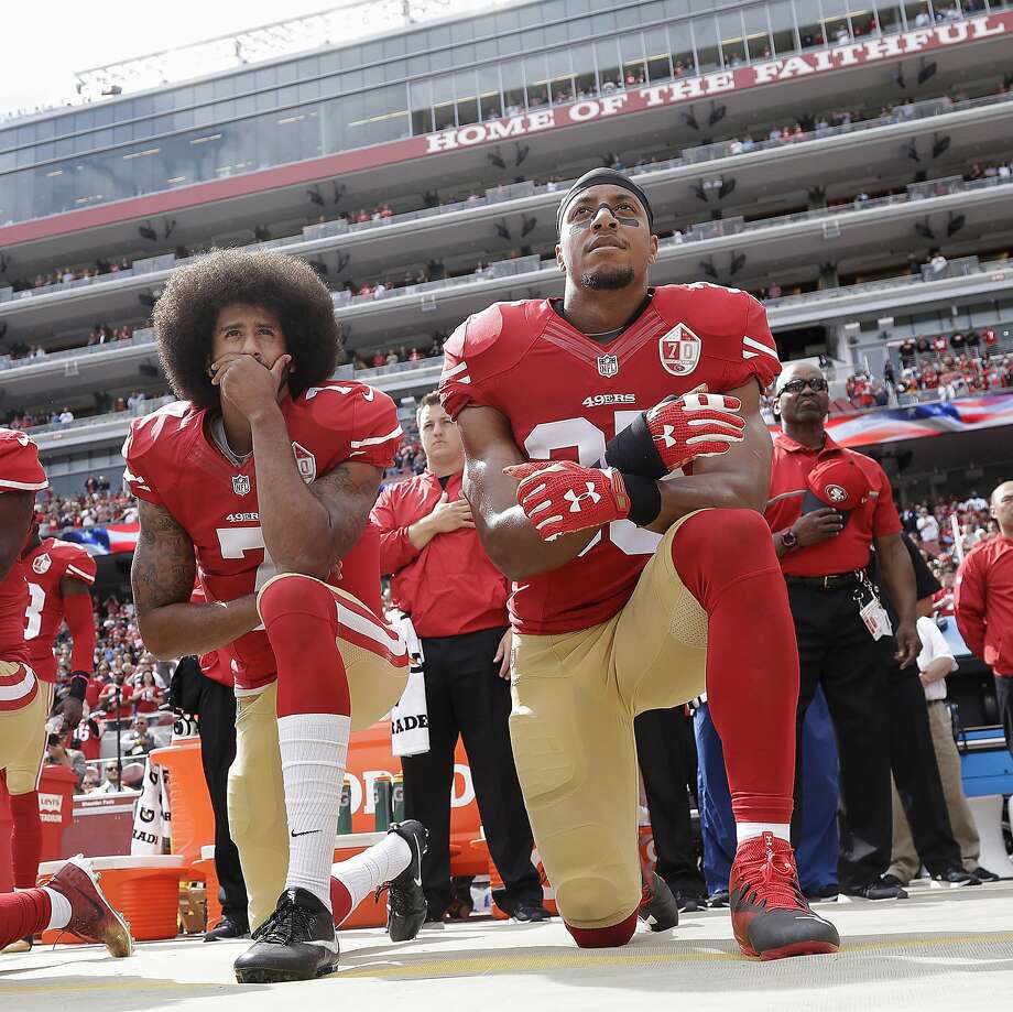 1 de setembro de 2016 - Kaepernick (L) é acompanhado por Eric Reid (R) de joelhos pelo hino nacional. Eles optaram por se ajoelhar em vez de se sentarem (como Kaepernick estivera fazendo) para demonstrar mais respeito pelos militares. Esta foto foi tirada um mês depois, em 2 de outubro de 2016, antes de um jogo de futebol da NFL contra o Dallas Cowboys em Santa Clara, Califórnia. Foto: Marcio Jose Sanchez, Associated Press