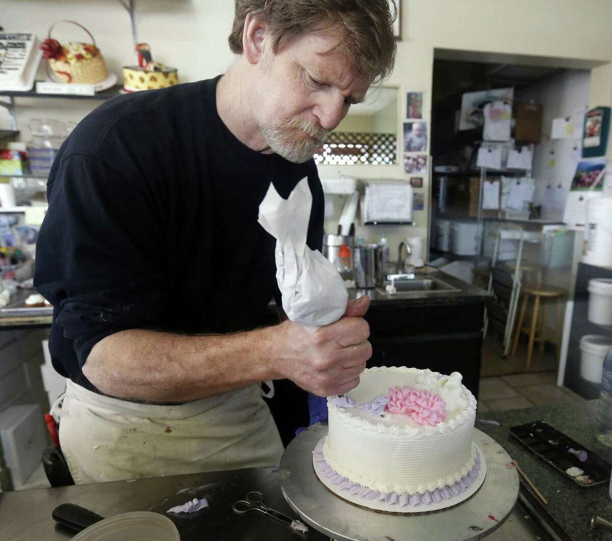 In this March 10, 2014, file photo, Masterpiece Cakeshop owner Jack Phillips decorates a cake inside his store in Lakewood, Colo. Prominent chefs, bakers and restaurant owners want the Supreme Court to rule against a Colorado baker who wouldnt make a cake for a same-sex couples wedding. The food makers say that once they open their doors for business, they dont get to choose their customers.