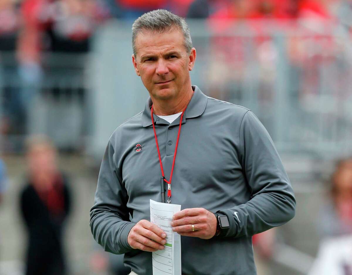 FILE - In this April 14, 2018, file photo, Ohio Setate coach Urban Meyer watches the NCAA college football team's spring game in Columbus, Ohio. Ohio State has placed Meyer on paid administrative leave while it investigates claims that his wife knew about allegations of abuse against an assistant coach years before he was fired last week. (AP Photo/Jay LaPrete, File)
