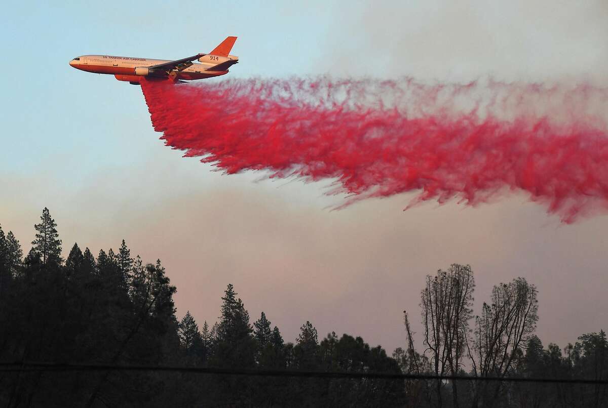 An air tanker drops fire retardent to try to contain flames from the Carr fire as it spreads towards the town of Lewiston near Redding, California, on August 2, 2018. Thousands of firefighters were struggling on August 2 to contain two vast wildfires in California, one of which has become one of the most destructive blazes in the state's history. The Carr Fire has scorched 126,00 acres (51,00 hectares) of land since July 23, when authorities say it was triggered by the "mechanical failure of a vehicle" that caused sparks to fly in tinderbox dry conditions.