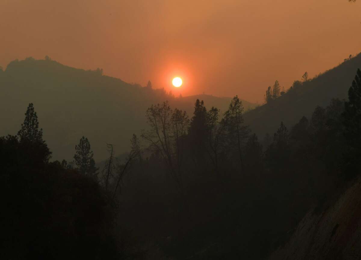 The sun sets over an area partially burnt by the Carr fire as it spreads towards the town of Lewiston near Redding, California, on Auigust 2, 2018. Thousands of firefighters were struggling on August 2 to contain two vast wildfires in California, one of which has become one of the most destructive blazes in the state's history. The Carr Fire has scorched 126,00 acres (51,00 hectares) of land since July 23, when authorities say it was triggered by the "mechanical failure of a vehicle" that caused sparks to fly in tinderbox dry conditions.