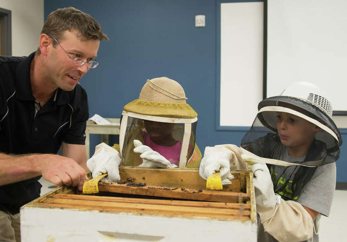 SIUE’s Jake Williams, PhD, educates Odyssey Science Camp students Theresa Iwayemi (middle) and Rhett Morris (right) on honeybees.