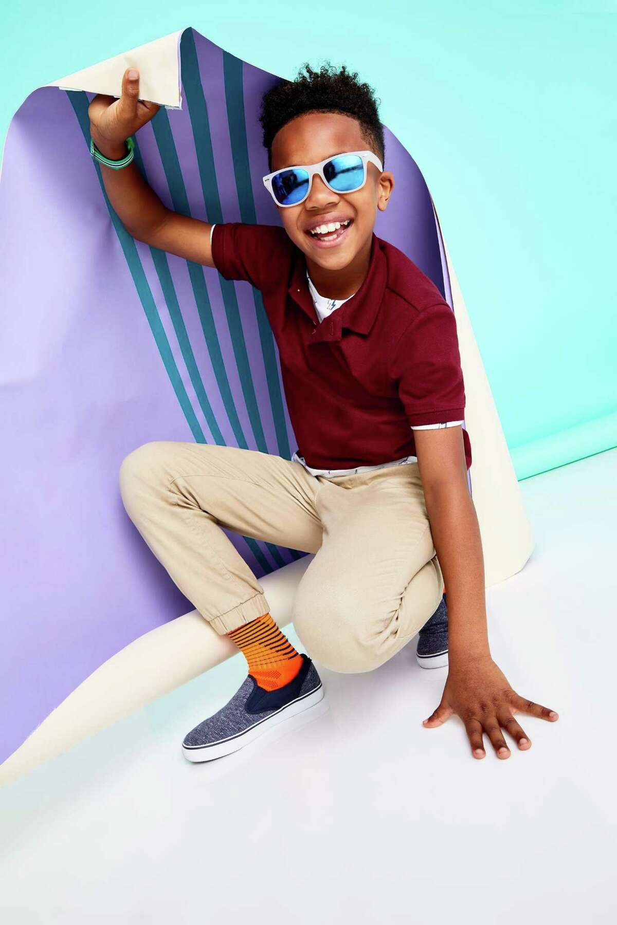 A model wears moisture-wicking uniform polo, $14.99, a straight built-in flex uniform pants, $24.99, and heathered-jersey slip-ons, $19.99. All from Old Navy.
