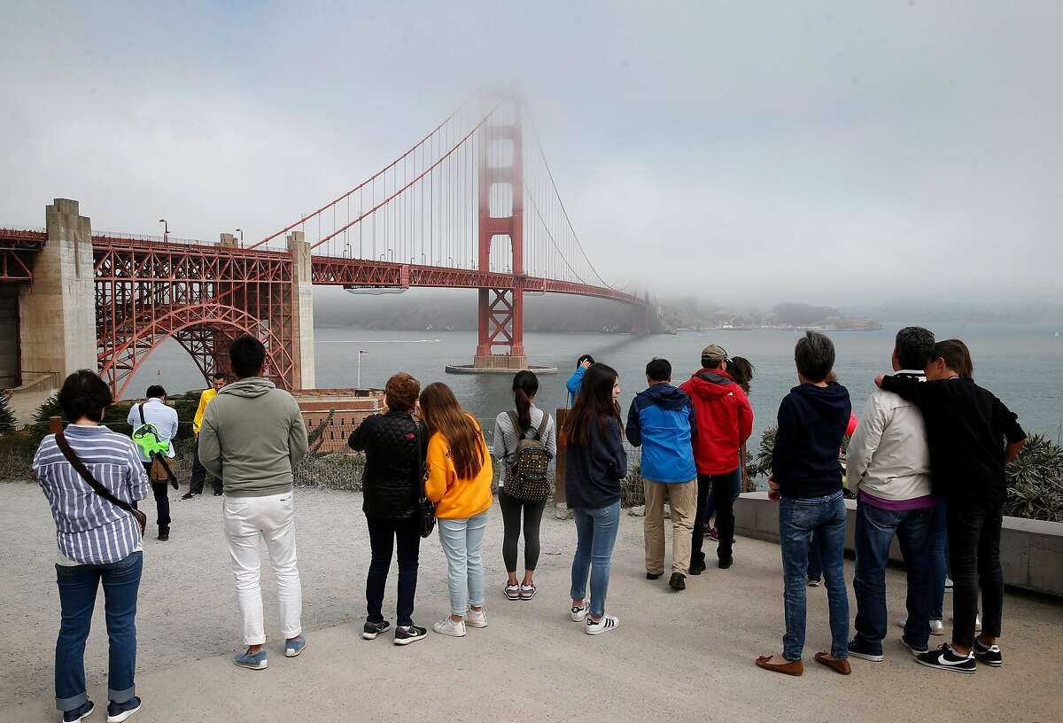 Visitors snap pictures of the Golden Gate Bridge in San Francisco, Calif. on Friday, Aug. 3, 2018. Construction on a new suicide deterrent barrier below the bridge’s deck will begin soon.
