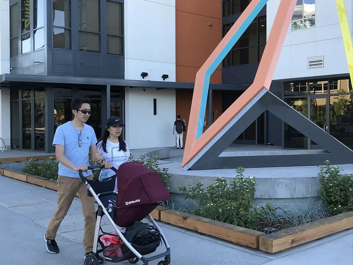 Newton Der and Jintai He walk their baby Maxwell Der past the new Station Park Green apartments in San Mateo. The new complex was developed by Essex Property Trust of San Mateo. August 3, 2018. Photo by Kathleen Pender/The Chronicle.