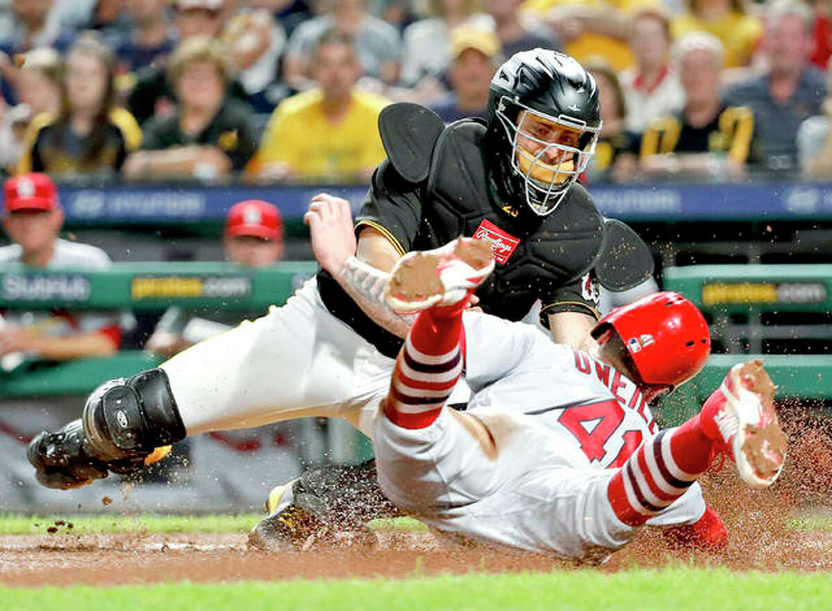 Pirates catcher Francisco Cervelli, top, tags out the Cardinals’ Tyler O’Neill during the eighth inning of Friday night’s game in Pittsburgh.