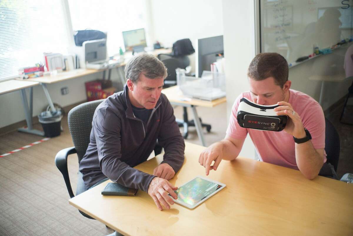 Doug Appleton, left, and Matt Mills demonstrate their headset's eye tracking capabilities at SyncThink in Palo Alto, Calif. on Friday, Aug. 3, 2018. The headset uses eye tracking to detect if users might be concussed.