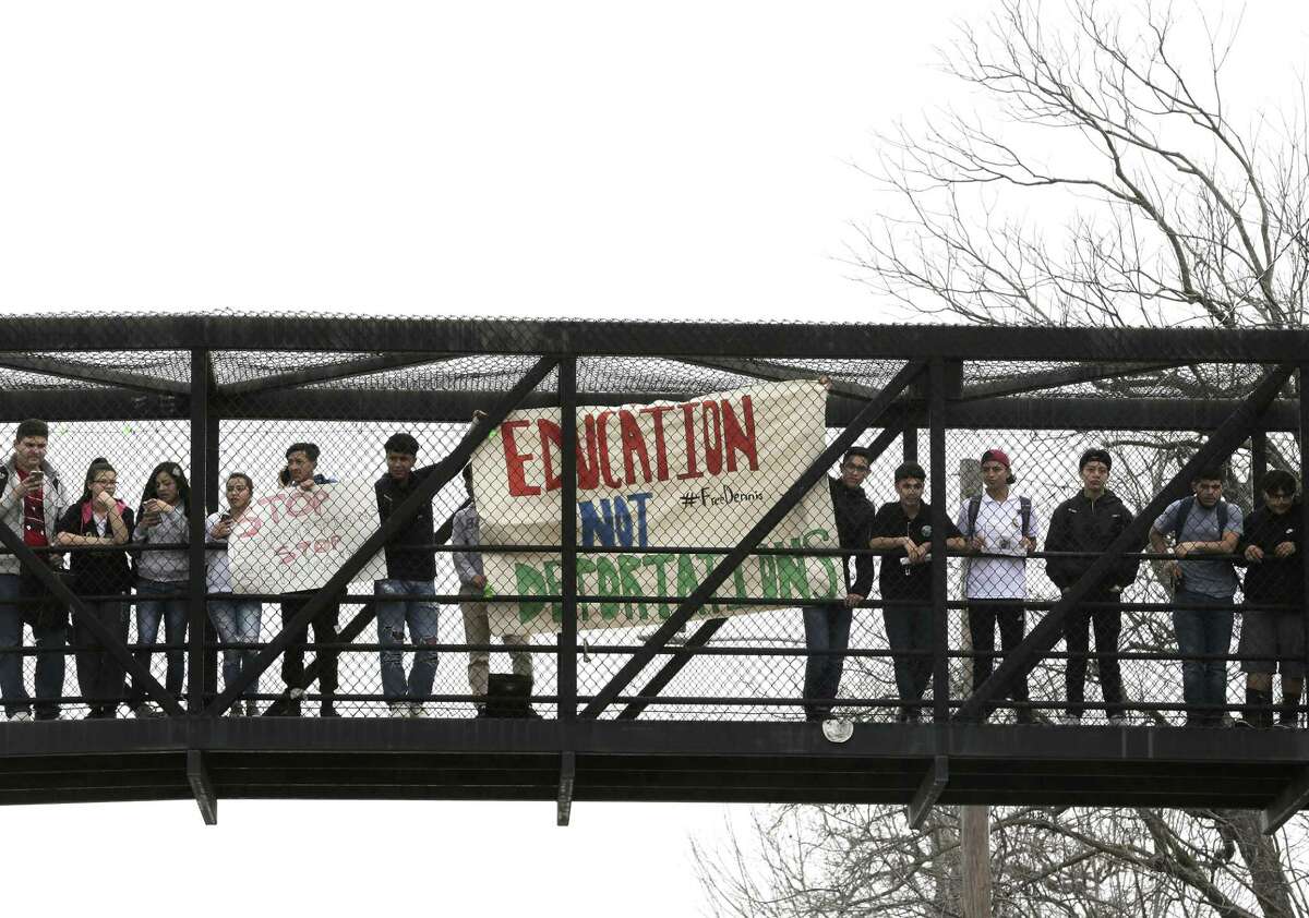 Austin High School students hold signs on the pedistrian bridge near the school protesting the ICE detention of Dennis Rivera, a student from their school on Wednesday, Feb. 14, 2018, in Houston. ( Elizabeth Conley / Houston Chronicle )