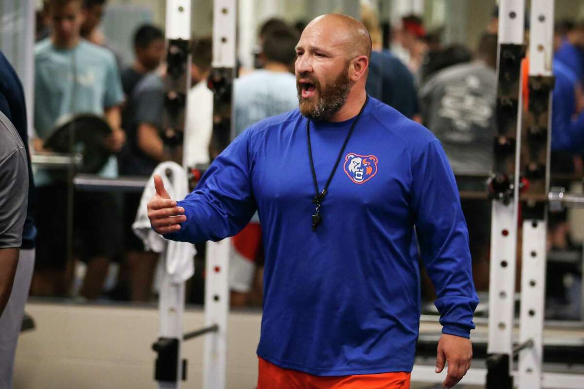 Brandon Rodriguez, Grand Oaks strength coach and football defensive coordinator, guides students through a weight room routine in June.