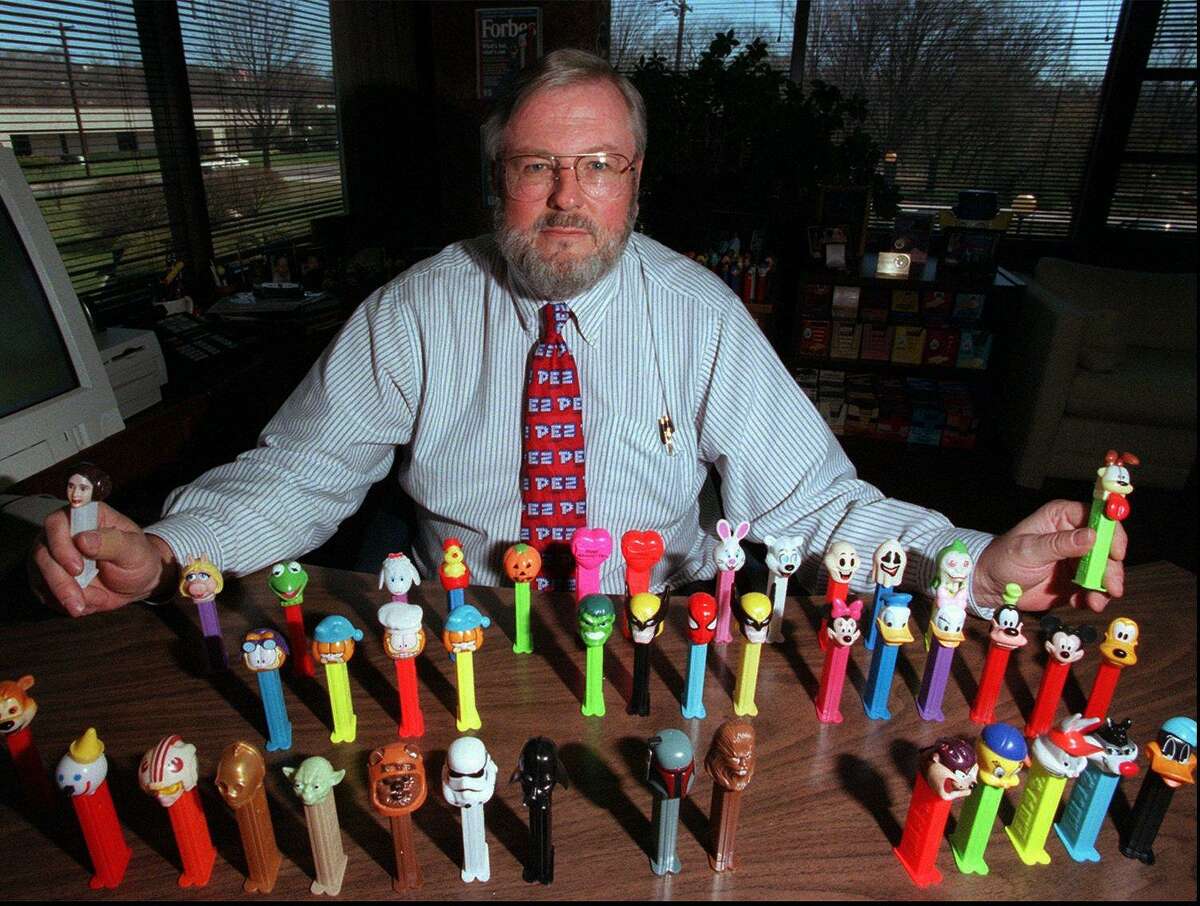 Scott McWhinnie, then-president of the Pez Company in Orange, poses in his office in 1999 with a few of current Pez Dispensers on the market.