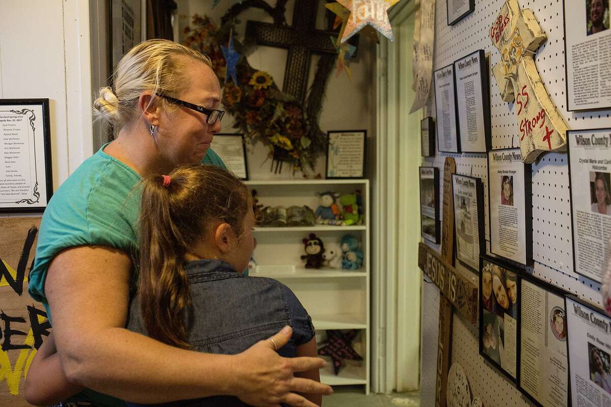 Robinn Alvizo embraces her daughter, Lillian Alvizo, 9, as they view the obituaries for victims, provided by the Wilson County News, in the Memorial Gallery on it's opening day at the Sutherland Springs Historical Museum on Saturday, August 4, 2018. Alvizo and her daughter were friends with some of the victims of the shooting.