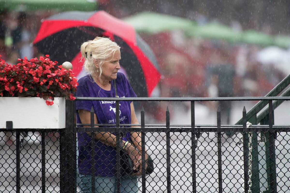 A racing patron endures the rains while waiting for #6 Diversify with jockey Irad Ortiz Jr. to go wire to wire winning 91st running of The Whitney Stakes Saturday Aug. 4, 2018 in Saratoga Springs, N.Y.(Skip Dickstein/Times Union)