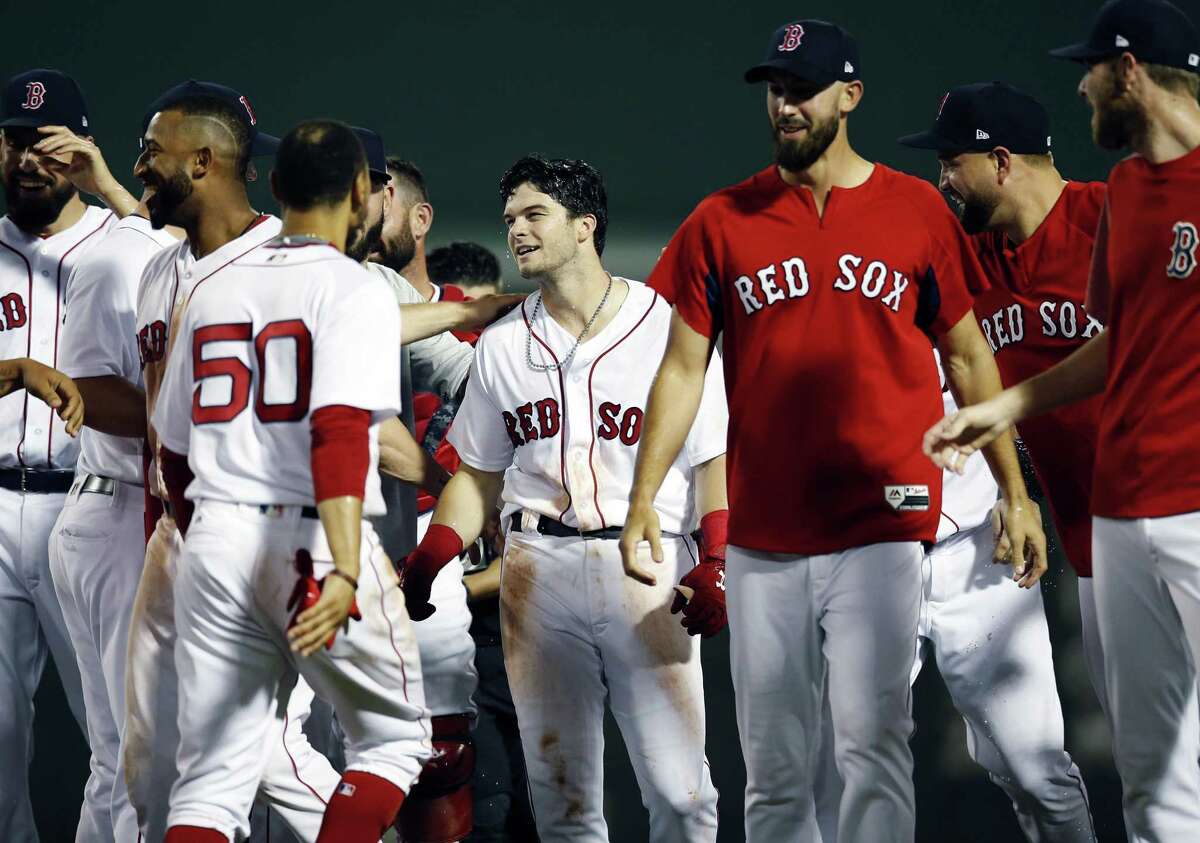 Andrew Benintendi, center, celebrates with teammates after driving in the winning run during the 10th inning against the Yankees on Sunday.