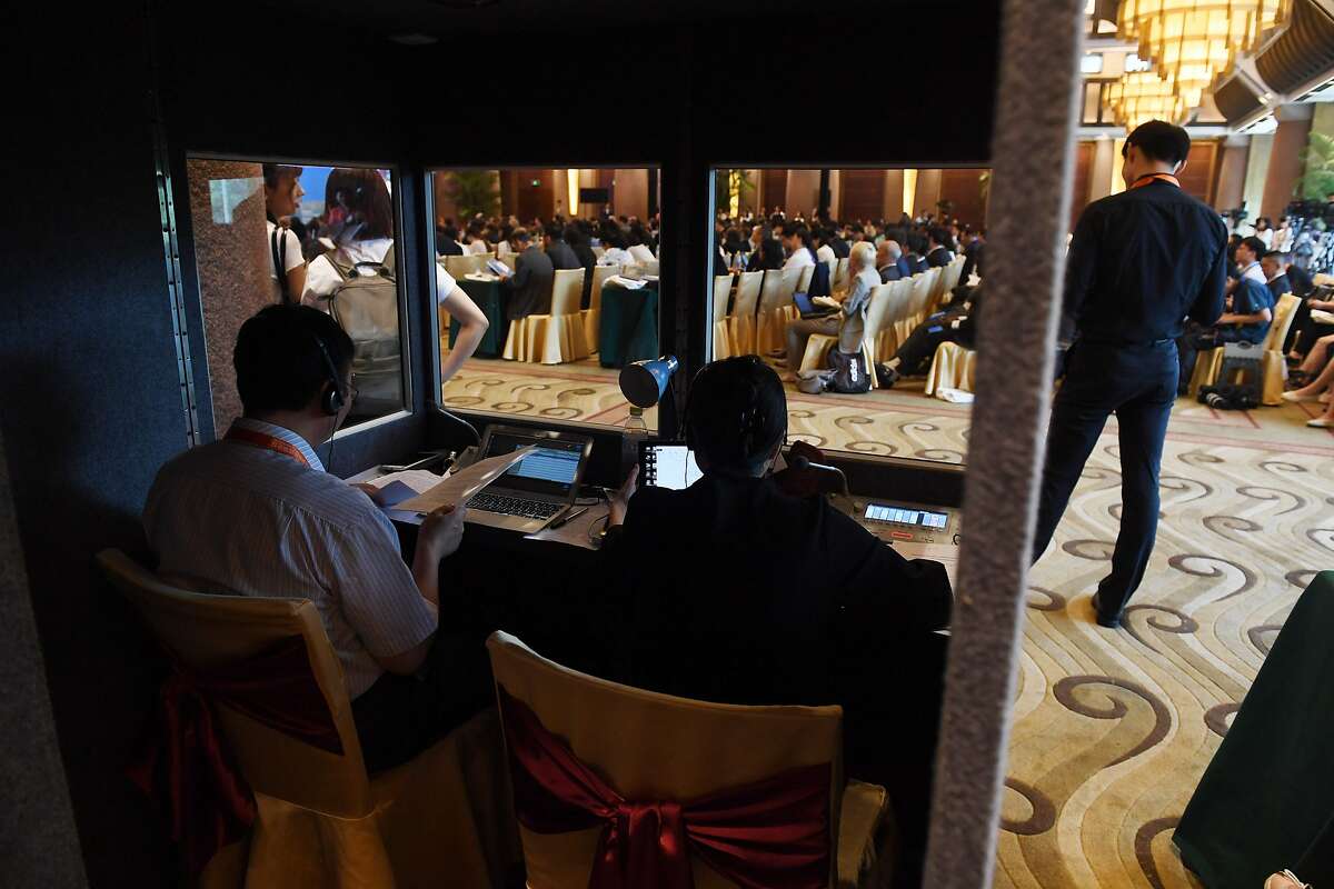 Translators work in a booth as delegates listen to speeches during the opening session of the Belt and Road Forum on Legal Cooperation at the Diaoyutai State Guesthouse in Beijing on July 2, 2018. / AFP PHOTO / GREG BAKERGREG BAKER/AFP/Getty Images