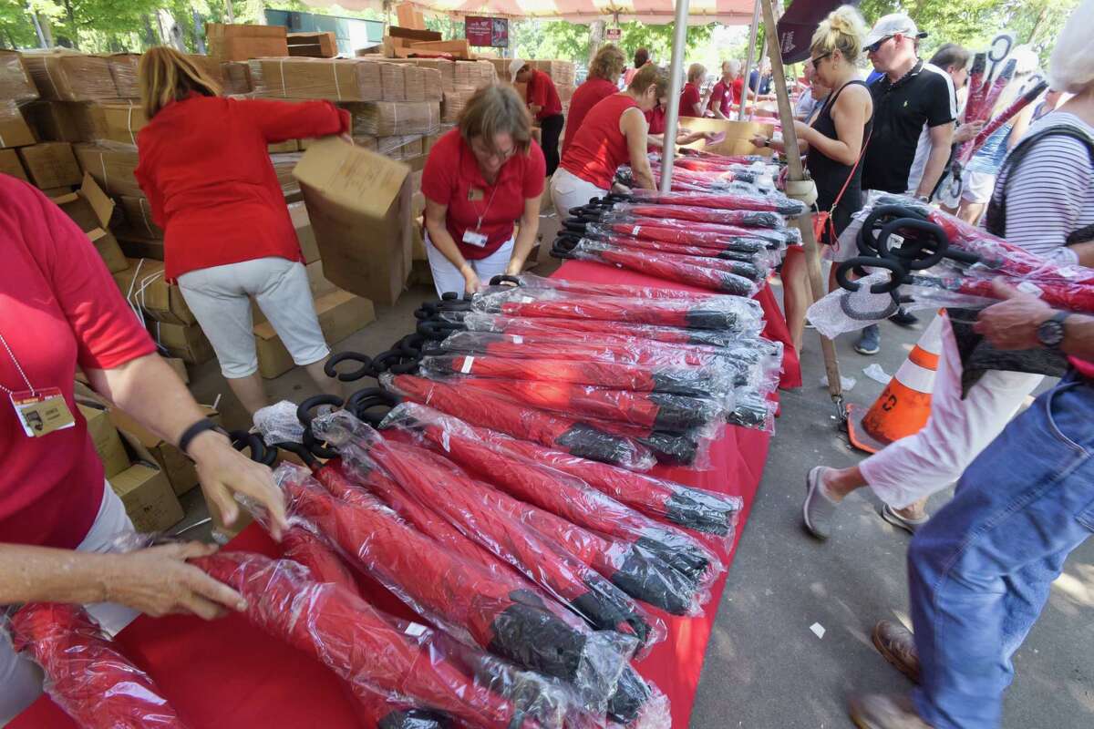 Workers hand out umbrellas as the give away for entrance at the Saratoga Race Course on Monday, Aug. 6, 2018, in Saratoga Springs, N.Y. (Paul Buckowski/Times Union)