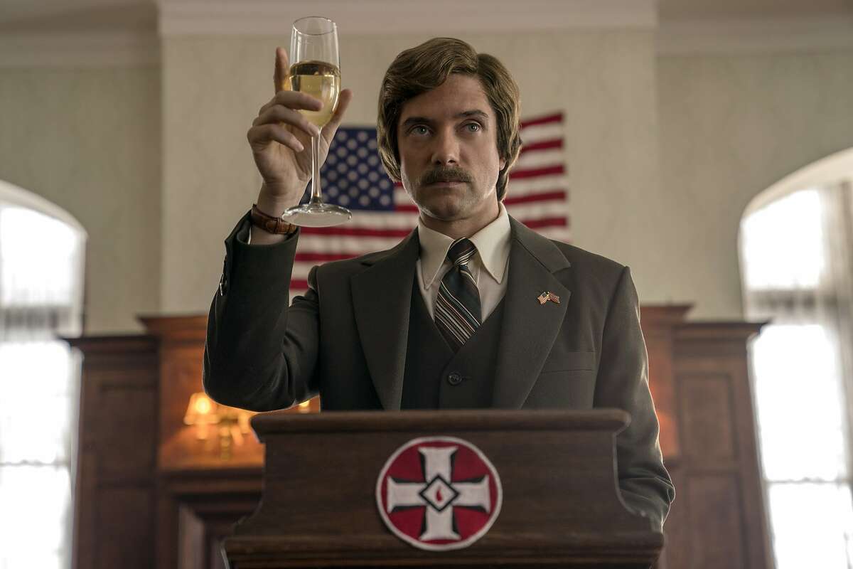 This image released by Focus Features shows Topher Grace in a scene from "BlacKkKlansman." Grace said he loves working in an ensemble and has done it often in his movies, including Traffic, Valentine’s Day, and "BlacKkKlansman," as well as his long running television show, "That 70’s Show." “It would be a nightmare for me to be in a movie like Castaway,” he joked. “A great ensemble is like a great sports team,” Grace said. “Steve is our Michael Jordan, but you pass the ball to someone else, they pass it to you. Everyone is going to do something great and everyone wins.” Grace’s character, Kurt, is a “lackey” who works for Carell’s character. Whether or not he believes in what Zimmer is doing or what the company he works for is doing, he does it to the best of his ability. He also says Carell’s character is somewhat of a father figure to his character. Satire approach Many of the comedic scenes occur due to the contrast of sophisticated Washington, D.C., political operatives trying to function in small town Wisconsin. Upon getting a Budweiser bottle on his first night, Carell’s character asks for a bottle opener, much to the amusement of the regulars. He can’t access the Wifi. The campaign staff is confronted with dial up service so they attempt to poach Wifi at a local school. As to how hard it was to keep a straight face during the movie with so many funny people, Grace summed it up by saying — “The blooper reel is going to be insane.”