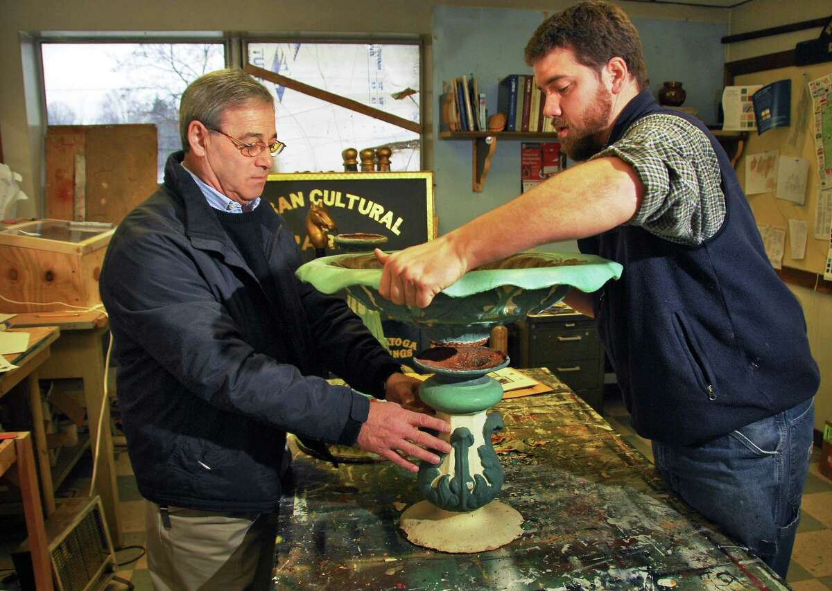 Saratoga Springs Public Works Commissioner Anthony "Skip" Scirocco, left, and city artist Phil Steffen works on one of the basins from the 1870's Morrissey Fountain in a workshop at the city's DPW garage Friday in 2008. (John Carl D'Annibale / Times Union)