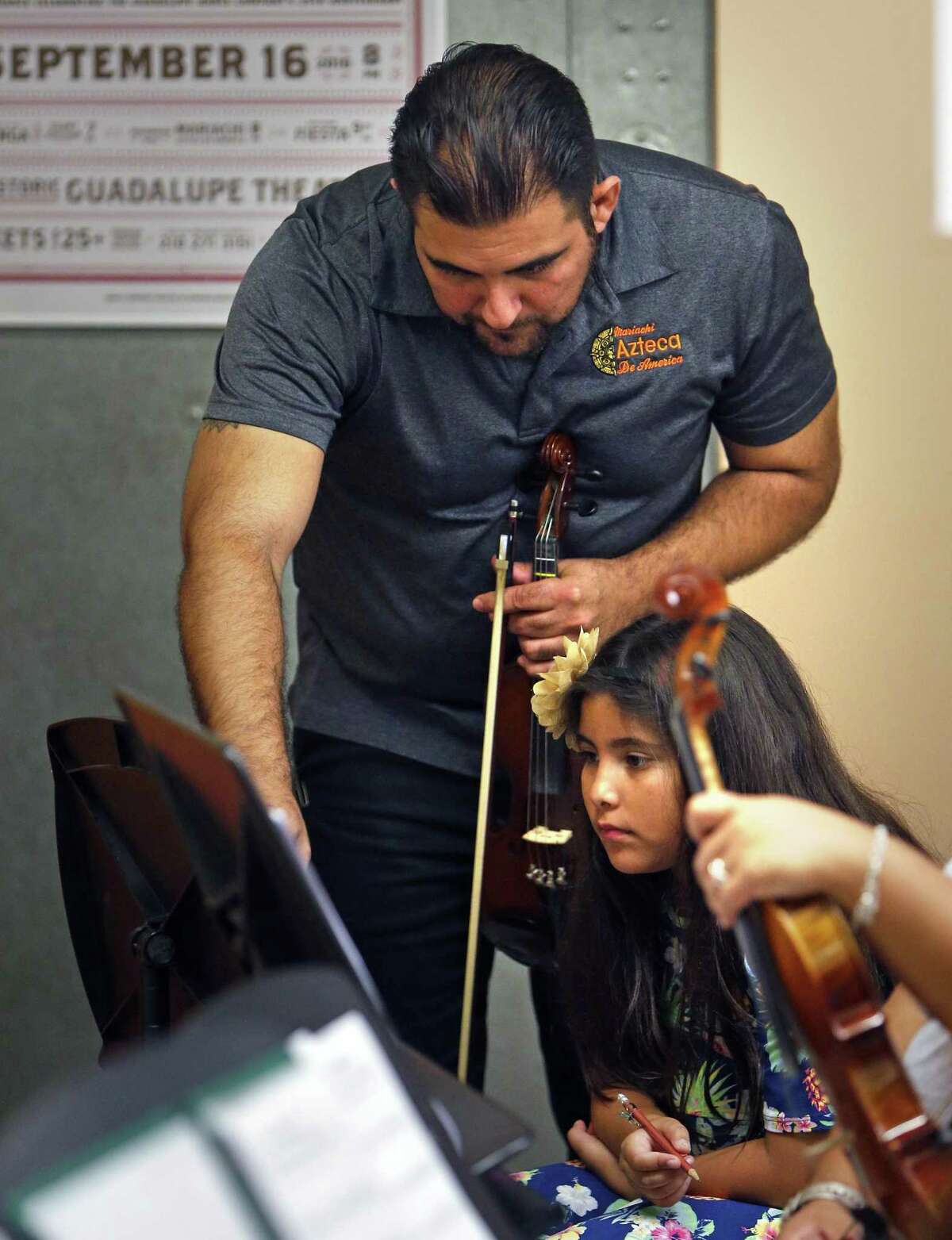 Gumecindo “Gino” Rivera, a violinist who leads and plays with Mariachi Azteca de America, works with 8-year-old Lolita Trujillo, one of the students taking part in mariachi camp at the Guadalupe Cultural Arts Center. Rivera has been named traditional music director at the Guadalupe Academy.