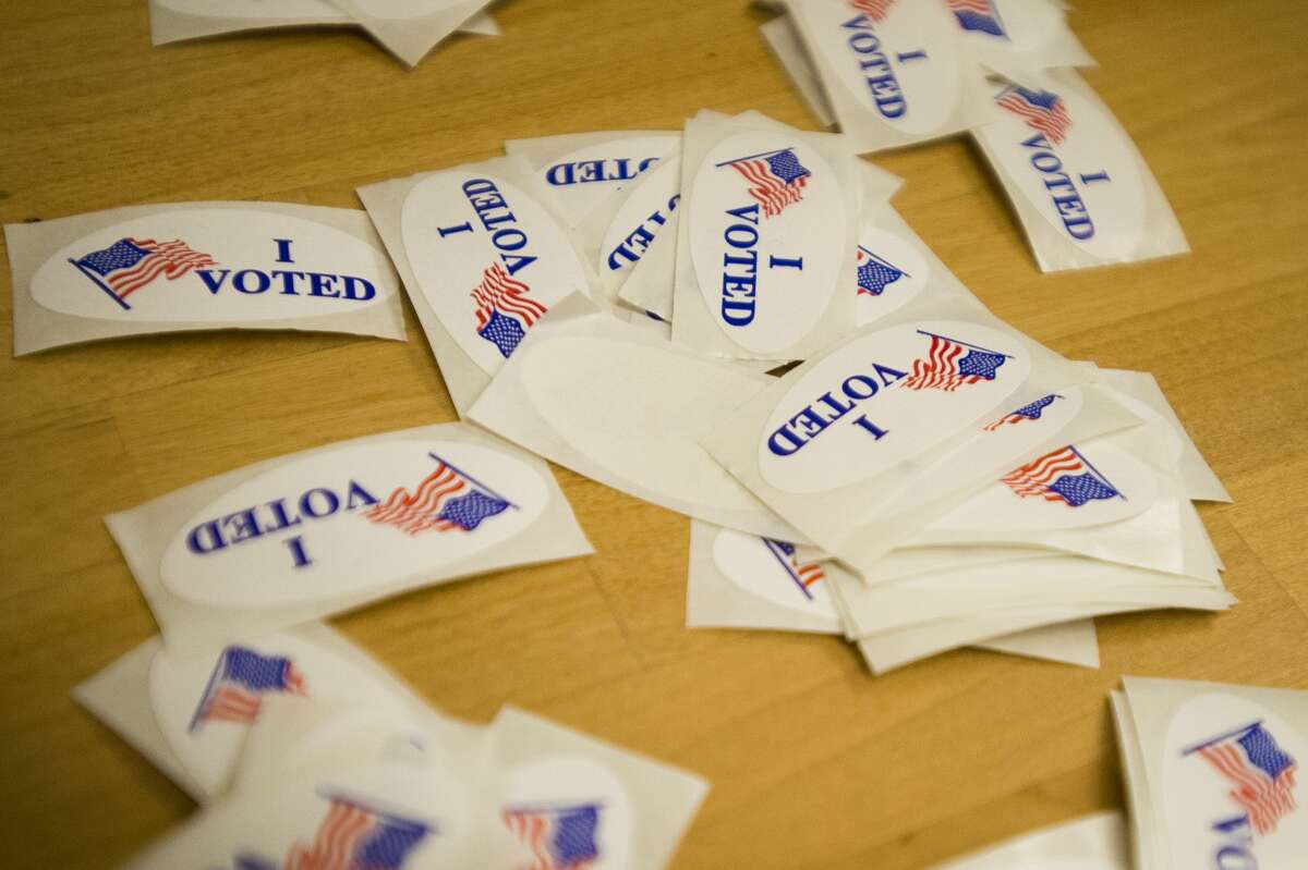 FILE — "I Voted" stickers sit on a table during the 2018 midterm primary elections in Midland. (Katy Kildee/kkildee@mdn.net)
