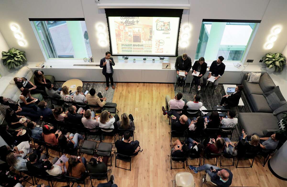 Guests listen as product pitches begin during pitch night for the new WeMRKT concept at WeWork in San Francisco Calif., on Tuesday, August 7, 2018. The company will partner with businesses, both food and dry goods retailers, to hold pop-up shops inside WeWorks, open to members and their guests.