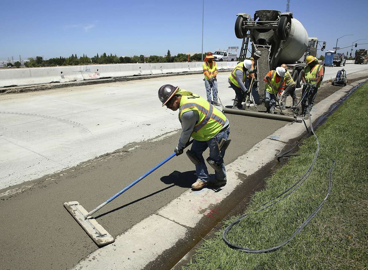In this July 11, 2018 photo, workers repave a street in Roseville, Calif., partially funded by a gas tax hike passed by the Legislature in 2017. Republican officeholders have plowed money into a November ballot initiative campaign to repeal the tax increase. (AP Photo/Rich Pedroncelli)