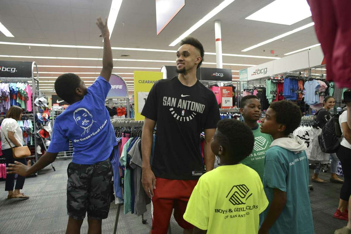 Marcus Menefee, left, shows Derrick White of the San Antonio Spurs how high he can jump during a back-to-school shopping spree at Academy Sports + Outdoors on Wednesday, Aug. 8, 2018. About 60 children from San Antonio Boys & Girls Clubs were treated to the event.