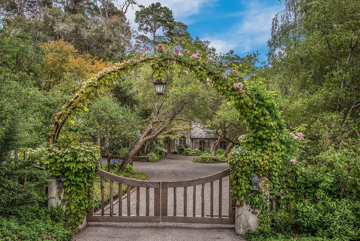 A rose covered wrought-iron arched entry gate built by John Hudson of Point Lobos Forge waits before the home.�