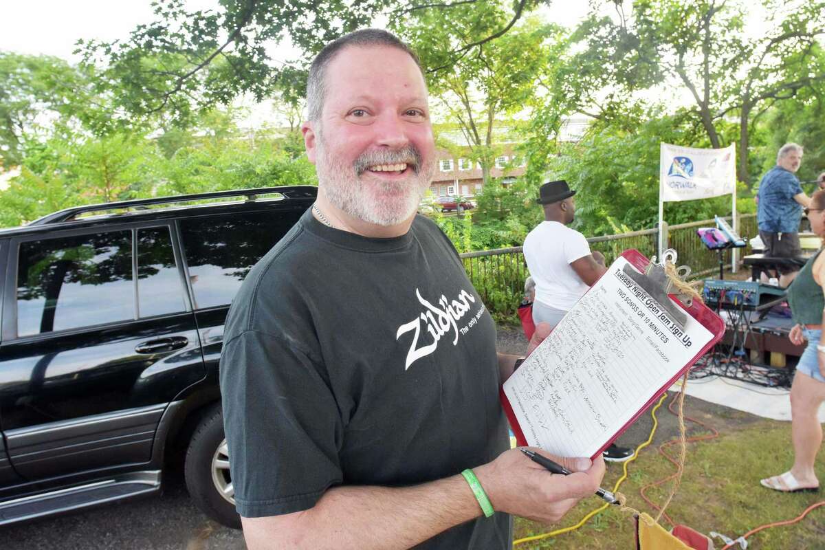 Norwalk's Dave Lindsay, clipboard in hand, runs Tuesday's Open Jam Night at Norwalk's Freese Park. He also occasionally sits in on drums with the house band Smokin' Charlie.