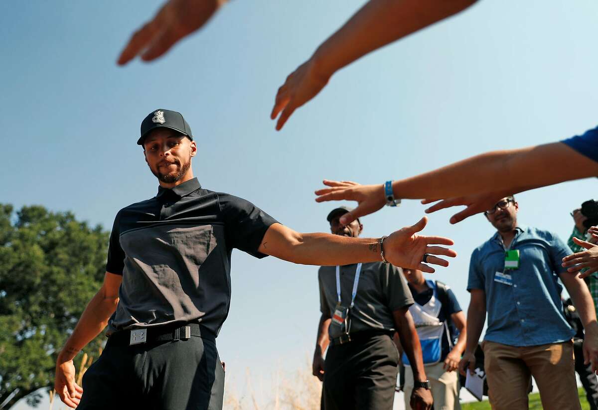 Golden State Warriors' Stephen Curry slaps hands with fans during 1st round of Ellie Mae Classic at TPC Stonebrae in Hayward, Calif. on Thursday, August 9, 2018.