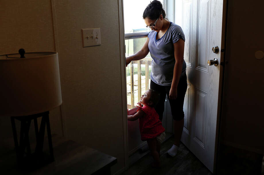 Danielle Kelley waits to let her dog, Cha be-be, back in with her daughter, Raeleigh, 1, at her home in Cibolo on July 10, 2018. (Lisa Krantz | San Antonio Express-News) / San Antonio Express-News