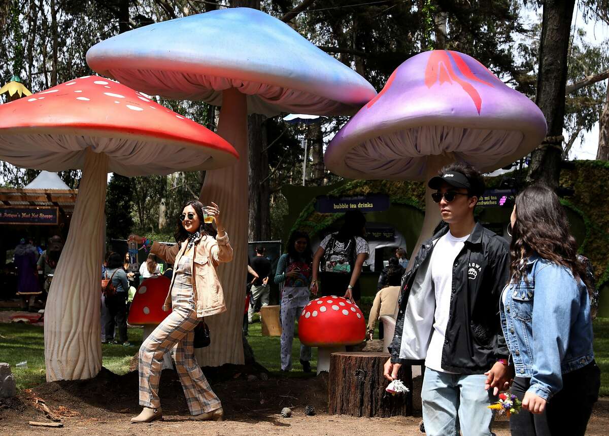 Kiana Pestonjee (name cq'd) poses for a photo in front of gigantic mushrooms in the Grand Artique area at Outside Lands at Golden Gate Park in San Francisco, Calif., on Friday, August 10, 2018.