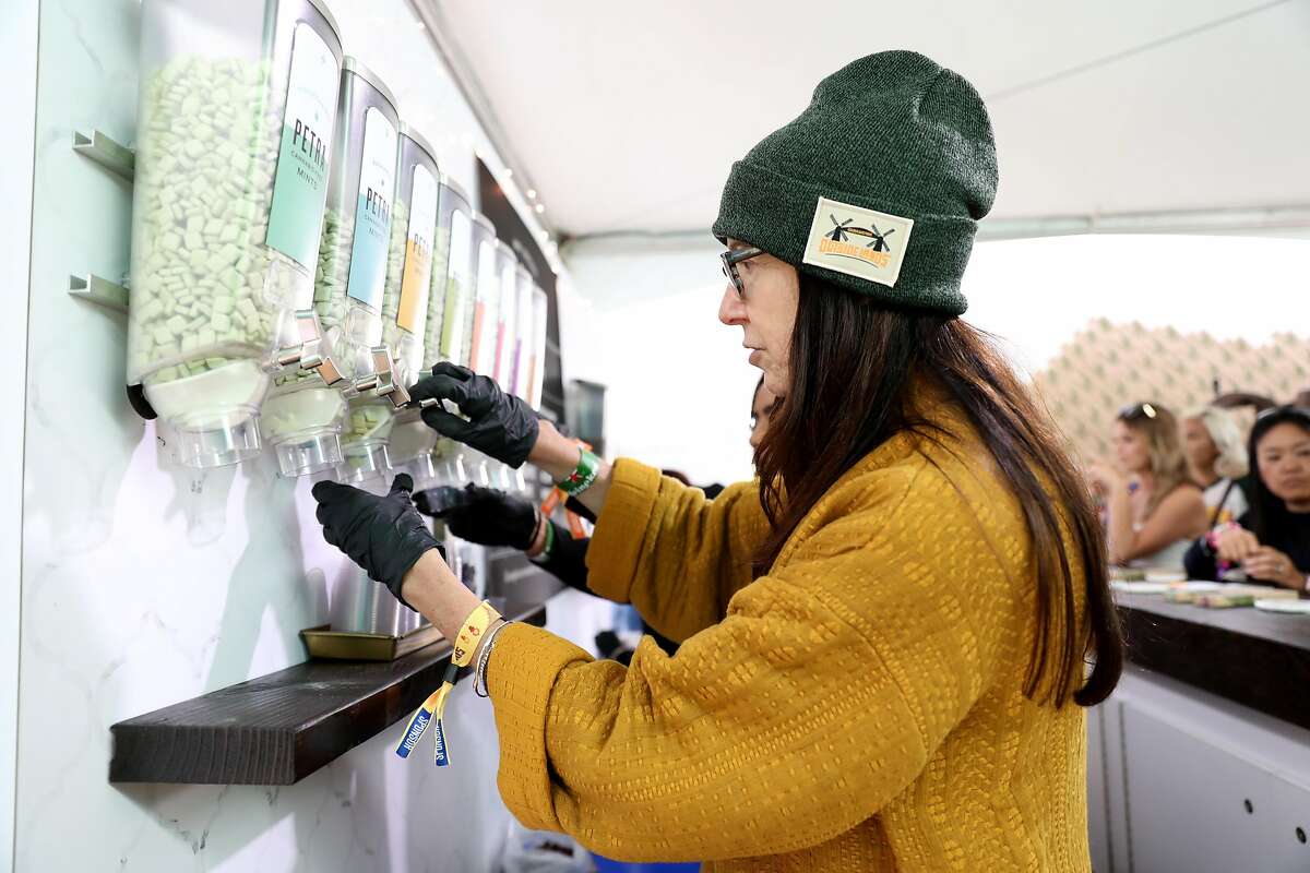 Susan Gentile dispenses mints at the Kiva Confections booth inside the Grass Lands area at Outside Lands at Golden Gate Park in San Francisco, Calif., on Friday, August 10, 2018. Grass Lands is the first marijuana exhibit at a major music festival.