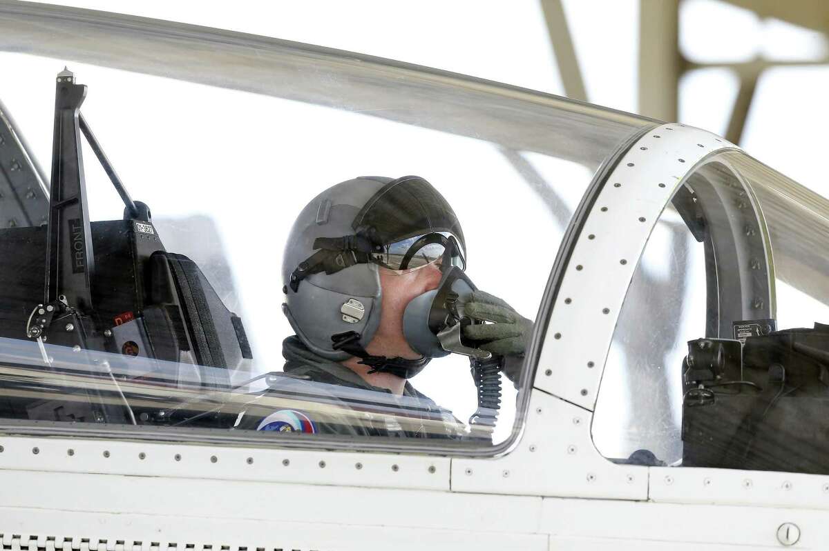 A pilot adjusts his oxygen mask as his crew prepares to fly T-6A aircraft at Joint Base San Antonio-Randolph on March 2, 2018.