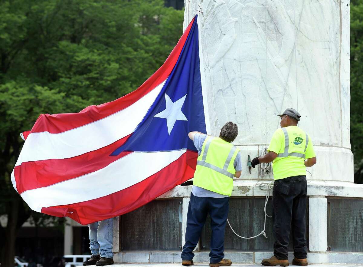 FILE - New Haven Parks, Recreation and Trees employees prepare the Puerto Rican flag to be raised on the New Haven Green in honor of the Third Annual New Haven Puerto Rican Festival in 2018. 