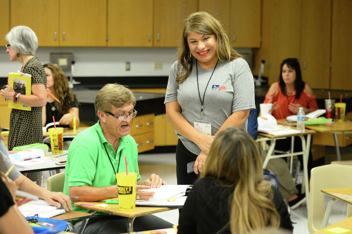 Lety Amalla, standing, Midland ISD’ ESL/bilingual director, works with teachers at Lee High School in this file photo.