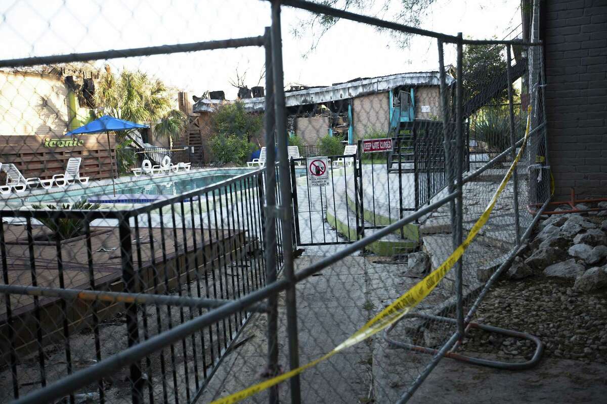 The fenced-off remains of the Iconic Village Apartments in San Marcos are shown. Building 500, in the background, was gutted by a fire that erupted two hours before dawn on July 20. Five people died and a sixth suffered severe injuries.