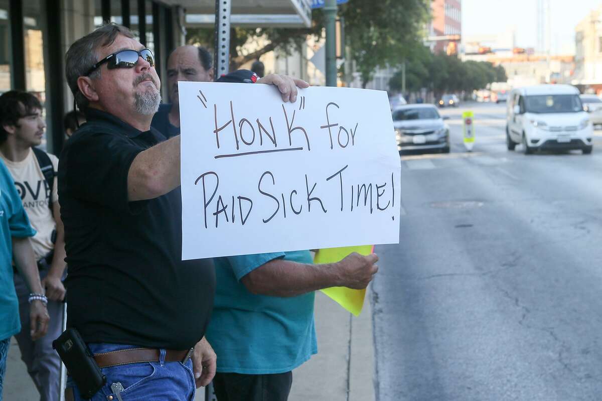 Rick Sisk holds up a “Honk for Paid Sick Time!” sign to passing cars as members of Working Texans for Paid Sick Time rally in front of City Hall about a proposal for mandatory paid sick leave Aug. 2, 2018.