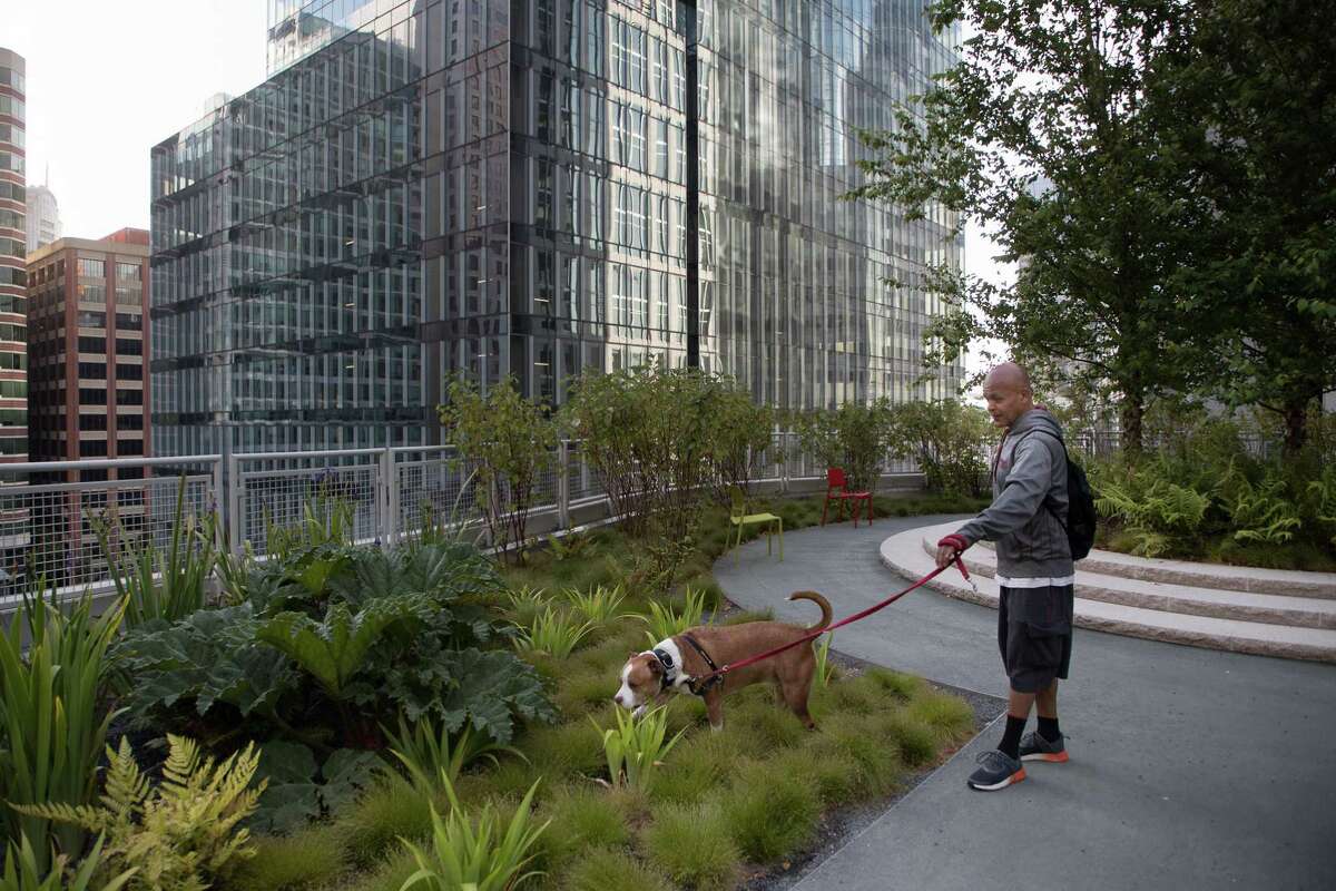 Raul Garcia walks his dog, Lucky, in the transit center’s rooftop park.