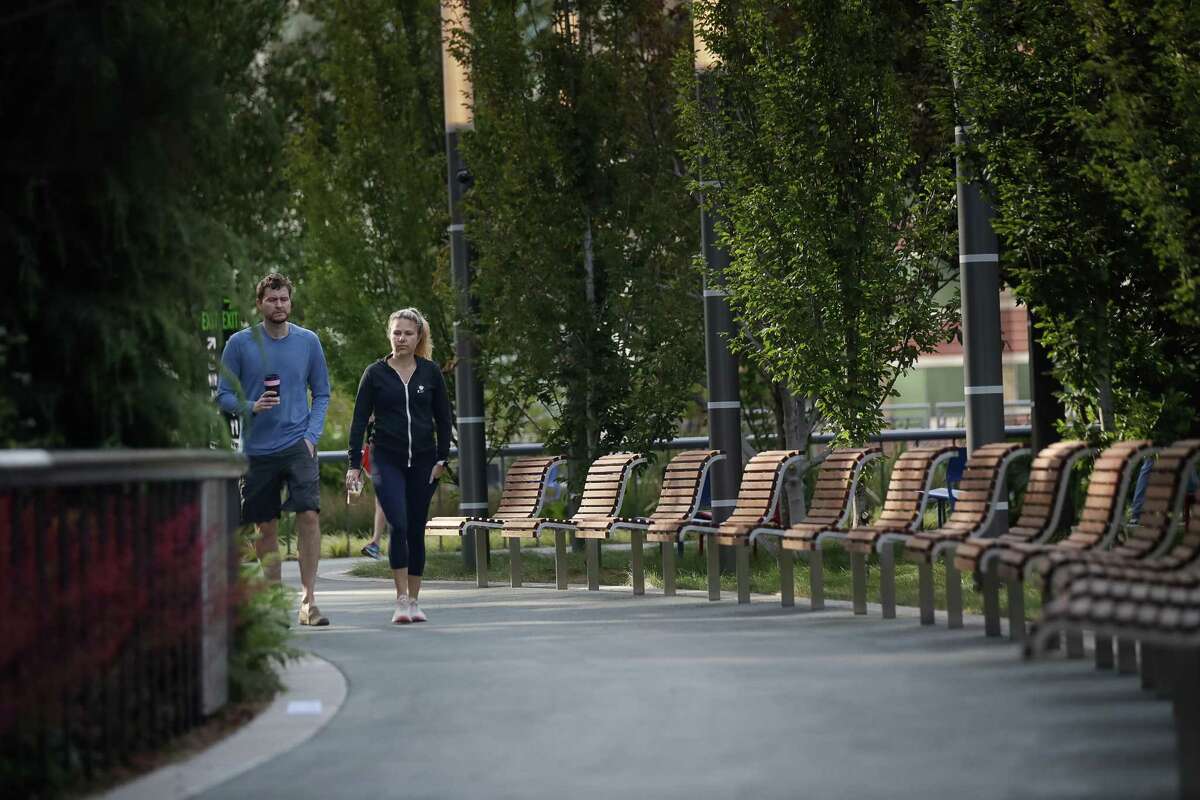 Chris and Amanda Kopel, who live next door, walk at Salesforce Park atop the transit center.