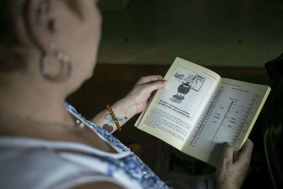 Laurie Nelson looks through her copy of “The Liver Cleansing Diet” by Dr. Sandra Cabot, at her home in Cibolo on Aug. 10, 2018. Nelson recently learned she no longer has nonalcoholic steatohepatitis, or NASH, after 19 years of having the disease. She credits the book, research she did online and bariatric surgery, which helped her lose weight.