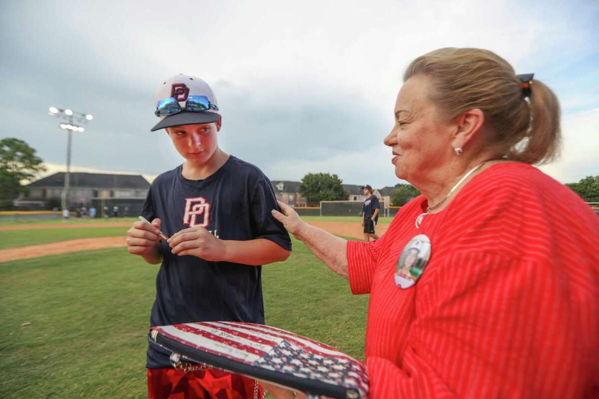 Post Oak Little League team Andy Guy receives words of encouragement after signing fan Kay Clinton's purse in advanced to the Little League World Series on Thursday, Aug. 9, in Houston.