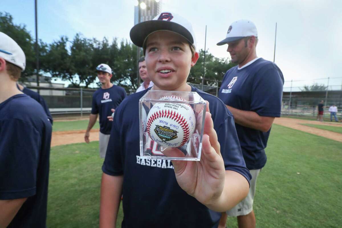 Post Oak Little League player Andrew Stover shows a team signed ball in advanced to the Little League World Series on Thursday, Aug. 9, in Houston.