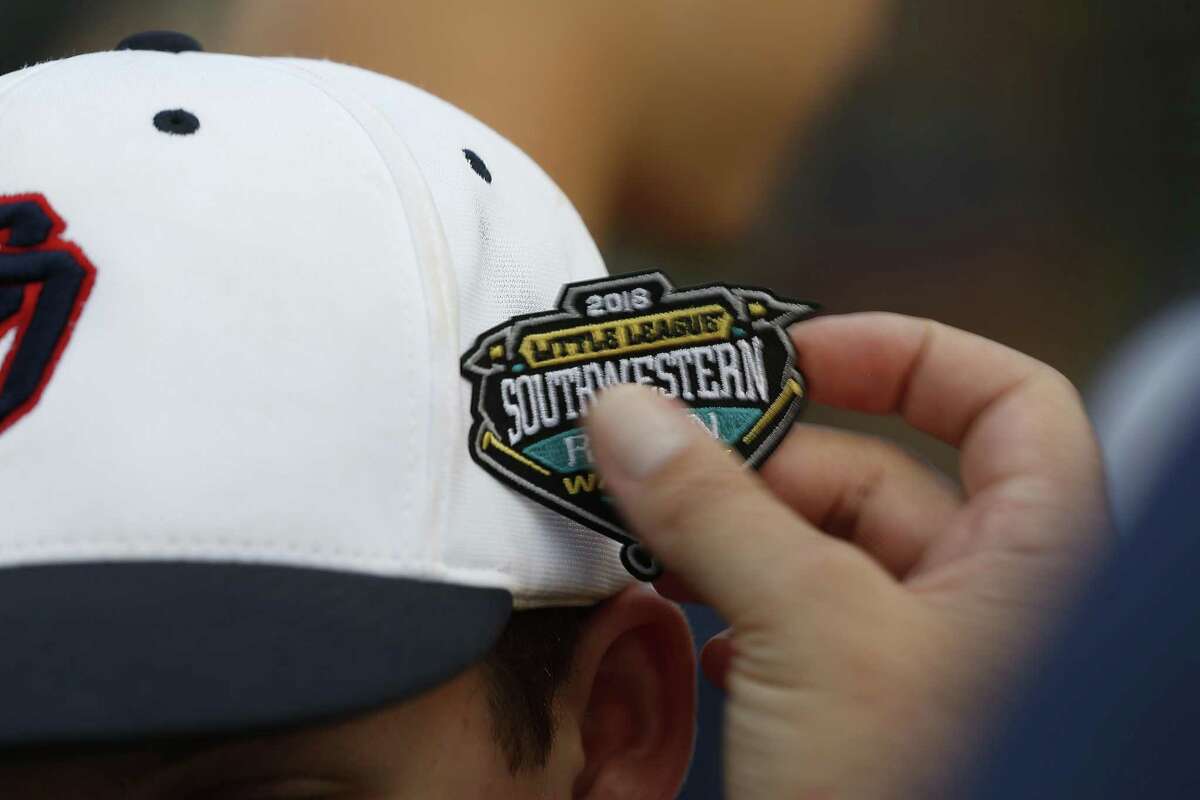 A Post Oak Little League player receives a new patch in advanced to the Little League World Series Thursday, Aug. 9, 2018, in Houston.