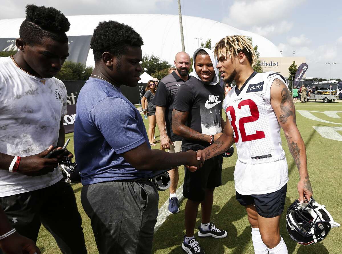 Houston Texans defensive back Tyrann Mathieu (32) shakes hands with C.E. King football player Rodrick Crumedy, as he and a few other King players visited training camp at the Methodist Training Center on Monday, Aug. 13, 2018, in Houston. The Texans donated last season's field turf to the school, after their stadium was flooded in the aftermath of Hurricane Harvey.