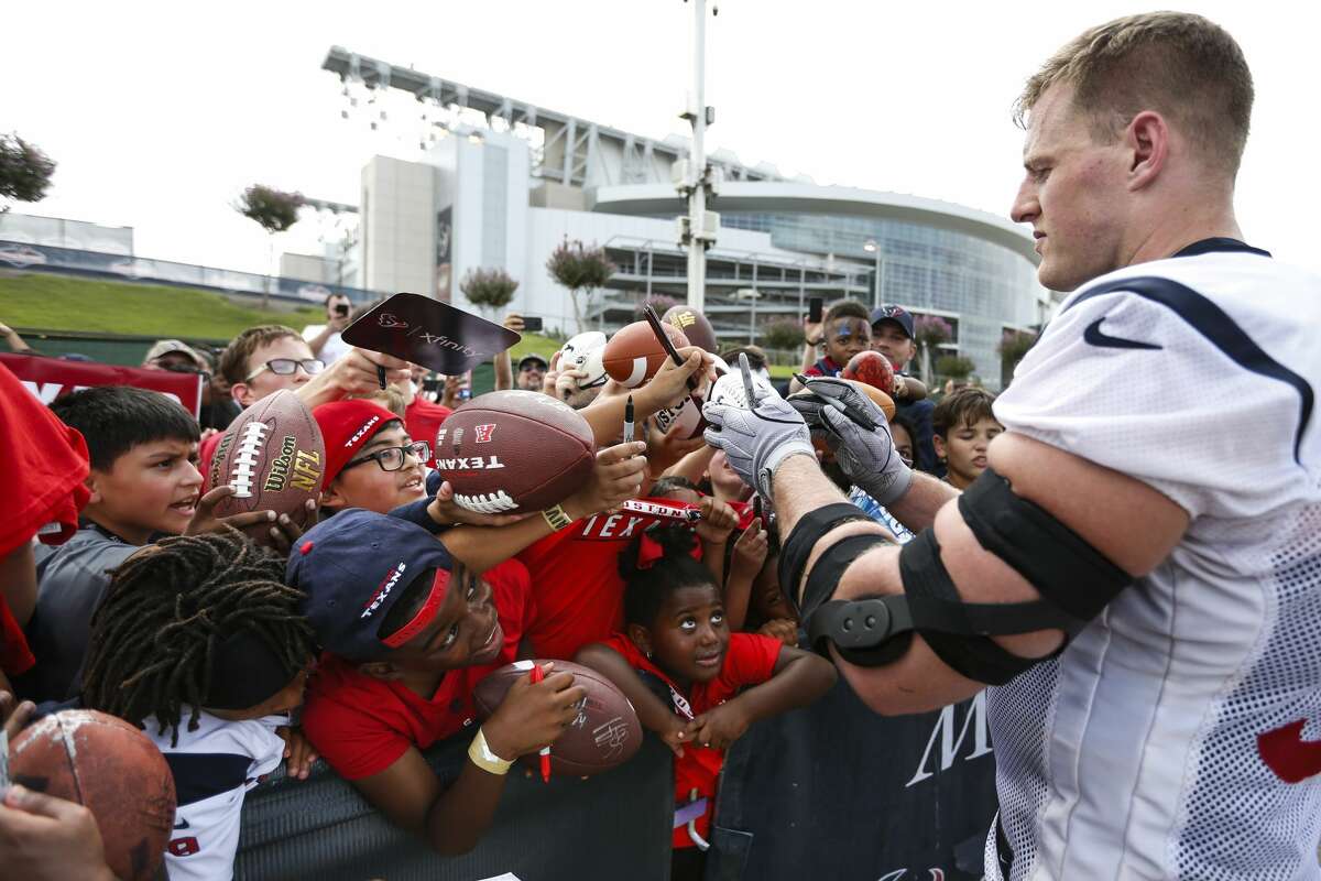 Houston Texans defensive end J.J. Watt signs autographs during training camp at the Methodist Training Center on Monday, Aug. 13, 2018, in Houston.