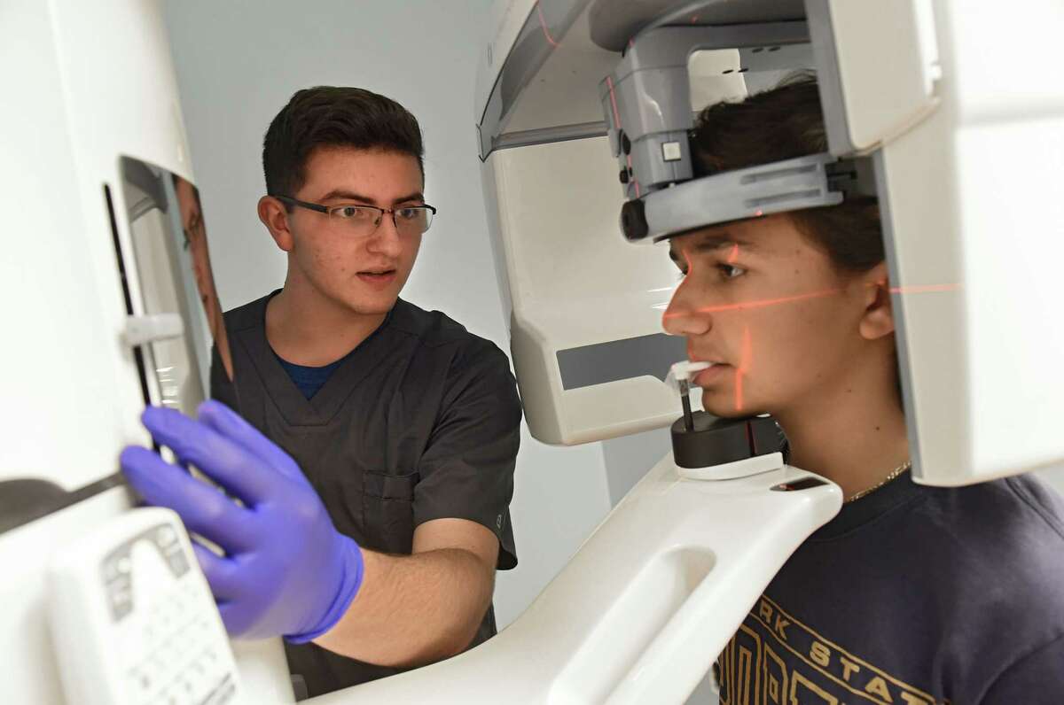 Dr. Sergey Berenshteyn's apprentice Joey Hayak, left, sets up an x-ray imaging machine for patient Anthony Fiore of Niskayuna at Adirondack Orthodontics on Wednesday, Aug. 8, 2018 in Latham, N.Y. (Lori Van Buren/Times Union)